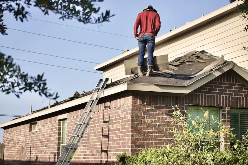 Professional roofer working on a residential roof in Bowman Manor